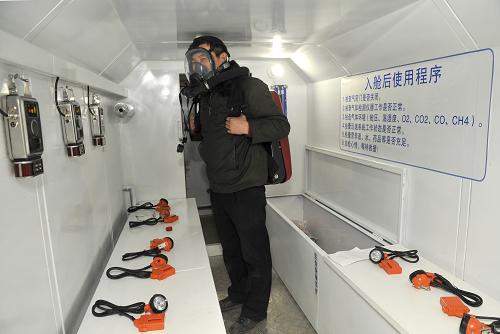 3月14日,技術人員在“礦用可移動式救生艙”的生存艙內展示艙內配備的用于井下出艙時使用的呼吸器等設備。新華社記者 劉瀟 攝