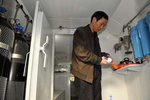 3月14日,技術人員在“礦用可移動式救生艙”的過渡艙內展示艙內配備的礦燈等設備。新華社記者 劉瀟 攝