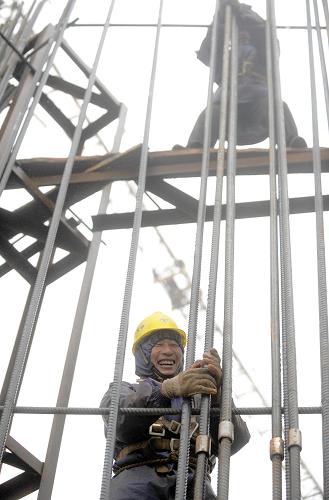 1月28日,施工人員在40多米高的橋墩上施工。新華社記者 徐昱 攝