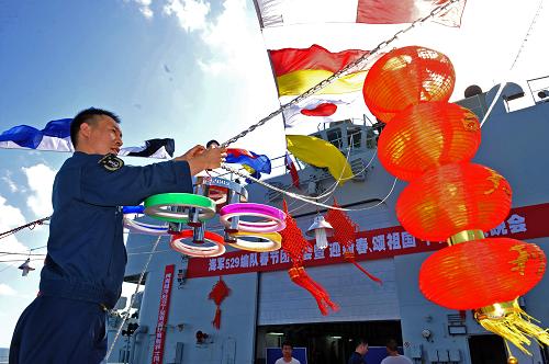 當(dāng)?shù)貢r間2月1日,一名中國海軍戰(zhàn)士在“千島湖”艦飛行甲板上布置團拜晚會會場。當(dāng)天,中國海軍第七批護航編隊“舟山”艦、“徐州”艦、“千島湖”艦在剛剛完成第291批護航任務(wù)后,利用漂泊待機的一天時間,三艦并靠,800名護航官兵首次在護航中相聚,歡慶2011年春節(jié)。官兵們每人領(lǐng)到了一份國內(nèi)捎來的慰問品“年貨”,除值更人員外,編隊還給每人發(fā)一瓶啤酒參加年夜飯聚餐。晚上在“千島湖”艦的飛行甲板上,舉行了別具一格的“大洋春晚”,各艦官兵表演了豐富多彩的文藝節(jié)目。2月2日清晨,護航編隊再次揚帆起航,執(zhí)行第292批21艘商船的護送任務(wù),并在三天的護航任務(wù)中度過除夕春節(jié)。新華社記者 范軍威攝