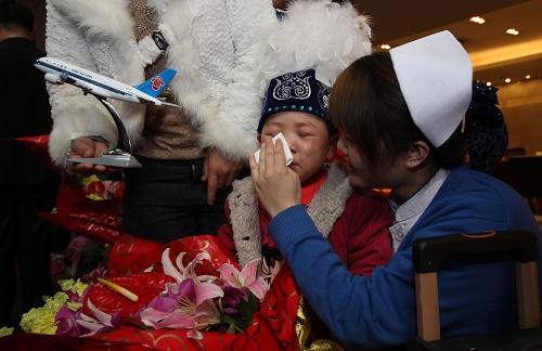 3月9日,北京首都國際機場國內(nèi)出發(fā)大廳,來自新疆的4歲女孩迪娜拉(中)與照顧她的護士阿姨依依惜別。新華社發(fā)(金立旺 攝)