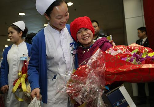 3月9日,北京首都國際機場國內(nèi)出發(fā)大廳,來自新疆的11歲女孩帕熱旦(右)與精心照顧她的護士阿姨依依惜別。新華社發(fā)(金立旺 攝)