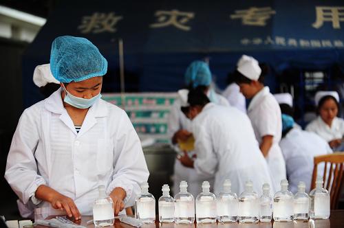 3月11日,盈江縣人民醫(yī)院的護士正在檢查藥水。新華社記者 秦晴 攝