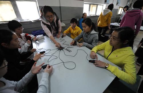 3月11日,在北京清華大學的體質測試現(xiàn)場,考生進行臺階運動測試后,考官用儀器為考生測量心跳。新華社發(fā)