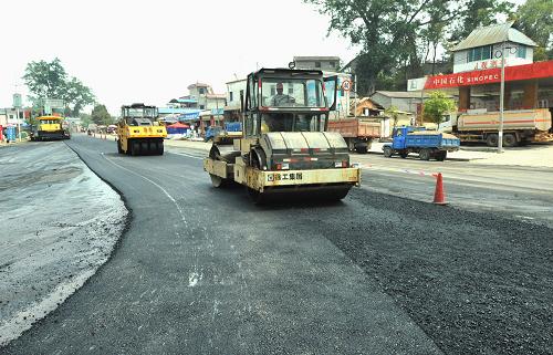 3月20日,大型筑路工程機械在鋪設(shè)騰沖縣至盈江縣2級公路通往縣城的最后路段。 當日,經(jīng)過10晝夜奮戰(zhàn)搶修,在云南盈江“3·10”地震中損毀的近20公里公路路基及70多公里路面,全部修復(fù)搶通,運輸救災(zāi)及恢復(fù)重建物資、人員通道暢通無阻,交通運輸?shù)玫交颈U稀?新華社記者 陳海寧 攝