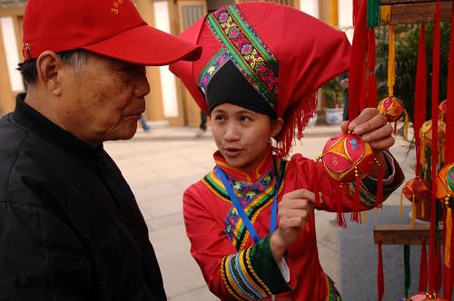4月7日,一位壯族姑娘向西安市民介紹壯族繡球。當(dāng)日,“第二屆西部非物質(zhì)文化遺產(chǎn)展演暨西安文化遺產(chǎn)博覽會(huì)”開(kāi)幕,來(lái)自西部各個(gè)省市自治區(qū)的百余位代表帶著當(dāng)?shù)氐姆俏镔|(zhì)文化遺產(chǎn)項(xiàng)目亮相西安大唐西市。
