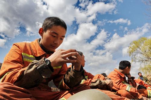 4月17日,在馬驛溝山上參加完滅火工作的一名戰(zhàn)士在用針挑扎在手上的刺。新華社記者 楊世堯 攝