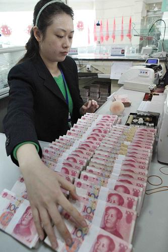 江蘇省贛榆縣一家銀行的工作人員在整理人民幣(3月19日攝)。新華社發(fā)(司偉 攝)