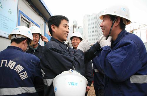 4月18日,在沈陽地鐵2號(hào)線沈陽市圖書館站施工現(xiàn)場,地鐵建設(shè)者在互相戴印有個(gè)人血型印記的安全帽。新華社發(fā)(黃金崑 攝)