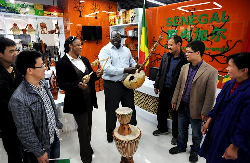 4月18日,義烏進(jìn)口商品館的塞內(nèi)加爾商位業(yè)主,彈非洲木琴吸引客人。當(dāng)日,新落成的浙江義烏國際商貿(mào)城進(jìn)口商品館開門迎客。進(jìn)口商品館匯集了來自55個(gè)國家和地區(qū)的27000余種特色商品,是一個(gè)集進(jìn)口商品批發(fā)、零售、展示、新品發(fā)布為一體的現(xiàn)代化商場式市場。新華社發(fā)(張建成 攝)