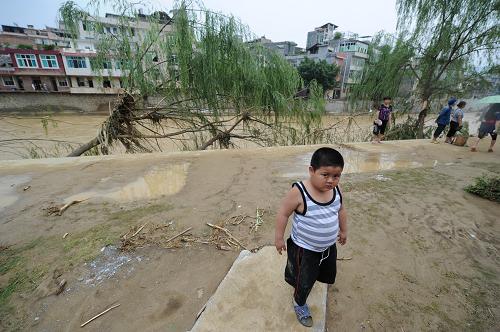 6月7日,一個孩子從被洪水肆虐過的望謨河堤上走過。截至6月7日,貴州暴雨洪澇災(zāi)害仍在持續(xù),全省14個縣市不同程度遭受暴雨洪澇災(zāi)害,受災(zāi)人口增至40余萬。災(zāi)情最重的望謨縣,目前據(jù)統(tǒng)計已死亡14人,失蹤52人。新華社記者 劉續(xù) 攝