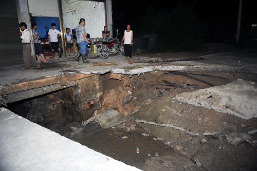 江西修水連夜轉(zhuǎn)移1500余人 受洪水沖擊,修水縣白嶺鎮(zhèn)鄧家咀村一戶民房前公路斷裂(6月10日攝)。 受特大暴雨影響,江西省修水縣白嶺鎮(zhèn)海拔700米高的山上,一座山塘出現(xiàn)裂縫。為確保安全,10日晚上,當(dāng)?shù)馗刹垦杆賱?dòng)員組織地勢(shì)較低的村民轉(zhuǎn)移,連夜轉(zhuǎn)移群眾1500多人。這些村民除了投親靠友之外,政府將鎮(zhèn)上的中小學(xué)、醫(yī)院等騰出來安置。6月9日深夜開始,江西省修水縣出現(xiàn)罕見特大暴雨,暴雨引發(fā)山洪暴發(fā)。 新華社記者周科攝