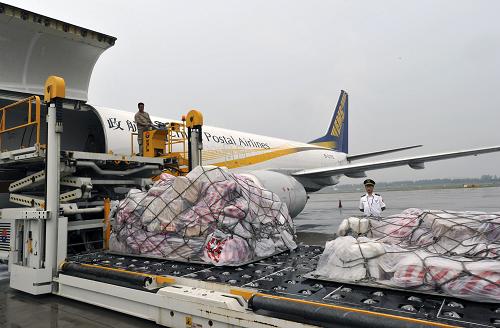 6月23日,中國(guó)郵政航空公司的飛機(jī)在青島流亭國(guó)際機(jī)場(chǎng)裝卸貨物。新華社發(fā)(崔鵬森 攝)
