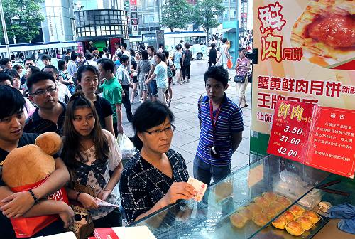 9月1日,顧客在上海市南京路上排隊購買月餅。上海的一些食品老字號生產(chǎn)的即買即食鮮肉月餅大受消費(fèi)者青睞。 中秋將至,上海市月餅市場上采用獨(dú)立包裝的散裝月餅,以豐富的品種和低廉的價格吸引了不少顧客選購,尤其是一些現(xiàn)場自制的月餅引得人們紛紛購買。 新華社記者 陳飛 攝