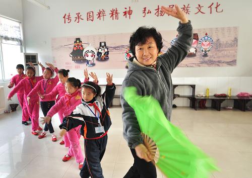 11月15日,鄒平縣梁鄒小學(xué)的教師在教授學(xué)生戲曲動作。山東鄒平縣梁鄒小學(xué)在課程設(shè)置中增設(shè)戲曲課程,按不同學(xué)段、學(xué)生愛好分別開設(shè)京劇、呂劇、黃梅戲等十幾種戲曲課程,并外聘專職教師授課,讓學(xué)生領(lǐng)略中國戲曲的魅力。據(jù)悉,該縣在70多所中小學(xué)的課程或活動中普遍開設(shè)了戲曲課。
