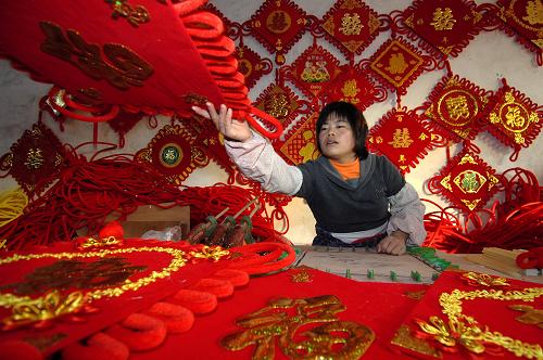 11月24日,在山東省郯城縣紅花鄉(xiāng)軒然工藝品廠,王琦在制作中國(guó)結(jié)。目新華社記者 郭緒雷 攝