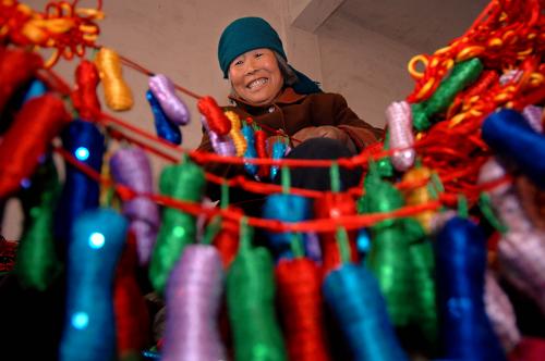 11月24日,在山東省郯城縣紅花鄉(xiāng)軒然工藝品廠,75歲的房德彩老人在制作加入布藝元素的中國(guó)結(jié)。新華社記者 郭緒雷 攝