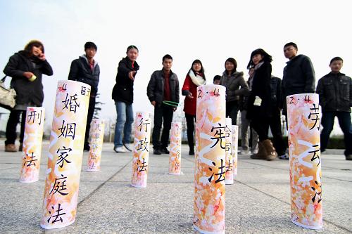 12月4日,江蘇淮陰師范學(xué)院的大學(xué)生用套圈游戲的方式回答法律知識問題。當(dāng)天是第十一個全國法制宣傳日,各地開展形式多樣的法制宣傳活動,提高人們知法、懂法、守法的意識。