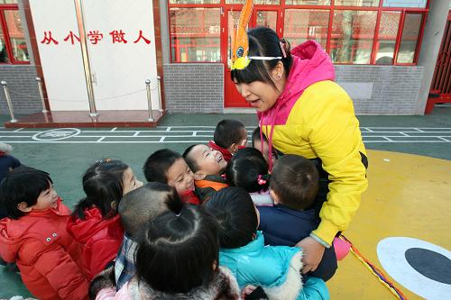 12月9日,在北京市東城區(qū)東四五條幼兒園分部,孩子們在新建幼兒園操場做游戲。新華社發(fā)(周良 攝)