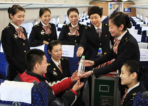 12月9日,天津客運(yùn)段津滬高鐵乘務(wù)員在進(jìn)行禮貌待客文明送售食品訓(xùn)練。 近日,為迎接即將到來的2012年春運(yùn),北京鐵路局天津客運(yùn)段對(duì)新職列車乘務(wù)員和津滬高鐵乘務(wù)員進(jìn)行為期兩周的技術(shù)業(yè)務(wù)素質(zhì)強(qiáng)化培訓(xùn),使其不斷提高服務(wù)旅客創(chuàng)先爭優(yōu)的思想意識(shí)。 新華社發(fā)(高錦旭 攝)