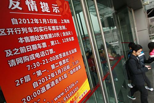 1月1日,旅客從鐵路上海南站售票處外的實名制公告牌旁經(jīng)過。新華社記者 裴鑫 攝