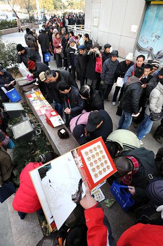 1月5日,購(gòu)買《壬辰年》特種郵票的市民在南京鼓樓郵政大廈外排起數(shù)百米長(zhǎng)隊(duì),一些郵迷在展示剛剛買到的《壬辰年》特種郵票和郵品,供大家觀賞交流。新華社記者 孫參 攝
