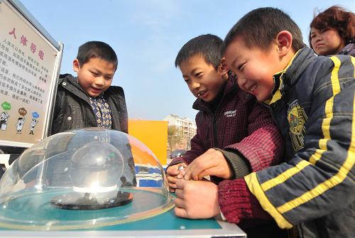 1月6日,幾名孩子在體驗(yàn)“人體導(dǎo)電”科普裝置。新華社記者 程敏 攝