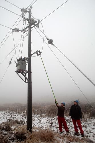 1月6日,廣西全州水利電業(yè)有限公司的工作人員在東山瑤族鄉(xiāng)清除高壓電線上的冰凌。新華社發(fā)(王滋創(chuàng) 攝)