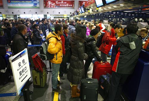 1月18日,在北京首都國(guó)際機(jī)場(chǎng),旅客在排隊(duì)辦理登機(jī)牌。新華社發(fā)(萬(wàn)象 攝)