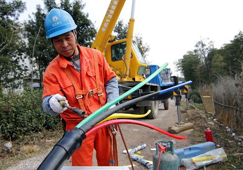 1月24日,搶修人員在制作電纜頭。 當日,浙江省長興縣顧渚村東風臺區(qū)變壓器出現(xiàn)故障,長興縣供電局緊急組織人員、調(diào)配車輛和材料,僅用2個小時就恢復了周圍500多居民的生活用電。春節(jié)期間,長興縣供電局精細制定了搶修值班方案,備足各類工具和防護用品,每天安排100余人和40多輛搶修車輛做好應急搶修準備,確保第一時間處理電力故障。新華社記者 徐昱 攝