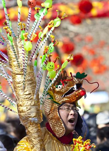 廟會(huì)上的“龍人” 1月24日,一名戴著“龍頭”棉帽的商販在北京廠甸廟會(huì)上叫賣。 在京城廟會(huì)上,人們以龍形服飾裝扮成各式“龍人”,營(yíng)造出濃濃的節(jié)日氣氛。 新華社發(fā)(趙冰 攝)