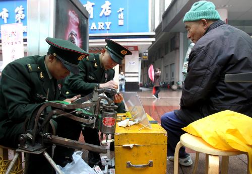 上海:南京路上學(xué)雷鋒 為民服務(wù)三十載 3月4日,南京路上好八連的戰(zhàn)士在為市民修鞋。 當(dāng)日,來自南京路上好八連、市區(qū)級(jí)單位、公益社團(tuán)等的300余名志愿者,在南京路步行街上開展學(xué)雷鋒為民服務(wù)活動(dòng),為市民提供130余項(xiàng)志愿服務(wù)項(xiàng)目。30年前,南京路學(xué)雷鋒為民服務(wù)活動(dòng)拉開序幕;30年來,每月的20日,南京路及周邊區(qū)域的單位和志愿者,始終堅(jiān)持開展學(xué)雷鋒為民服務(wù)活動(dòng)。 新華社記者 劉穎攝