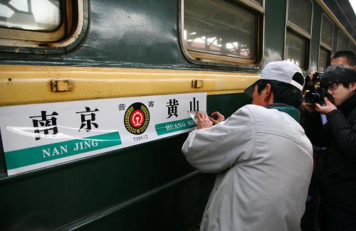 3月23日,一名工作人員將7102次火車標(biāo)識(shí)牌由“黃山至南京西”更換成“黃山至南京”。 新華社發(fā)(王新 攝)
