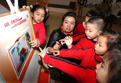 3月30日,六一幼兒園的小朋友們?cè)谟螒蛑兄赋鐾婢咧写嬖陲L(fēng)險(xiǎn)的小部件。新華社記者 劉穎 攝