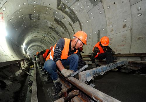 4月10日,中鐵一局杭州地鐵1號線軌道二標段的施工工人在剛剛澆筑完工的道床上進行清理、平整工作。 當日,隨著杭州臨平站最后25米混凝土的澆筑完成,中鐵一局杭州地鐵1號線軌道二標工程正式宣告全線整體道床施工完成,順利實現(xiàn)軌通。中鐵一局負責施工的杭州地鐵1號線二標線路長度29.383公里,約占1號線總長的61%。 地鐵1號線線路全長48公里,是杭州市首條開工建設(shè)的地鐵線路,工程于2007年3月28日開工建設(shè)。目前,杭州地鐵1號線已進入全面安裝、調(diào)試及裝修階段,計劃4月份實現(xiàn)全線“軌通”、“電通”,6月份開始空載試運行。 新華社記者 徐昱攝