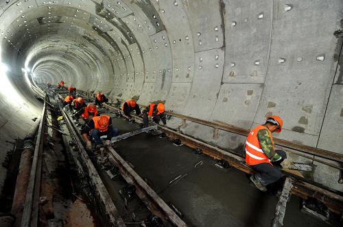 4月10日,中鐵一局杭州地鐵1號線軌道二標段的施工工人在剛剛澆筑完工的道床上進行清理、平整工作。 當日,隨著杭州臨平站最后25米混凝土的澆筑完成,中鐵一局杭州地鐵1號線軌道二標工程正式宣告全線整體道床施工完成,順利實現(xiàn)軌通。中鐵一局負責施工的杭州地鐵1號線二標線路長度29.383公里,約占1號線總長的61%。 地鐵1號線線路全長48公里,是杭州市首條開工建設(shè)的地鐵線路,工程于2007年3月28日開工建設(shè)。目前,杭州地鐵1號線已進入全面安裝、調(diào)試及裝修階段,計劃4月份實現(xiàn)全線“軌通”、“電通”,6月份開始空載試運行。 新華社記者 徐昱攝