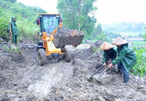 5月25日,在廣西凌云縣玉洪瑤族鄉(xiāng)玉保村,村民冒雨疏通被泥石流阻斷的道路。新華社記者 周華 攝