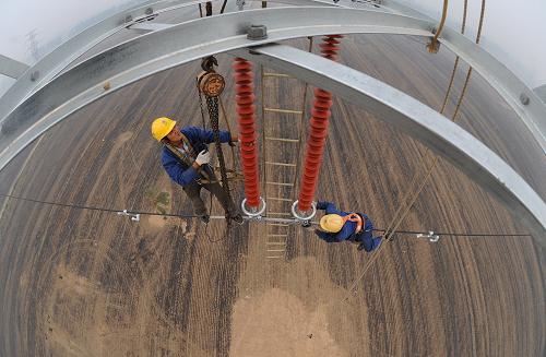 6月16日,在安徽濉溪縣,安徽送變電工程公司施工人員對(duì)輸電線路進(jìn)行技術(shù)改造。新華社發(fā)(宋衛(wèi)星 攝)