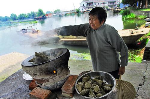 6月21日,浙江省嘉善縣姚莊鎮(zhèn)漁民村村民在煮篙秧粽子。篙秧粽子是漁民村的特色食品。當(dāng)?shù)貪O民生活以前較為艱苦,人們以隨處可見的篙秧代替箬葉包粽子。這一習(xí)俗后來(lái)被沿襲下來(lái),成為當(dāng)?shù)厝藨c端午活動(dòng)中一項(xiàng)具有區(qū)域特色的內(nèi)容。新華社發(fā)(胡凌翔 攝)