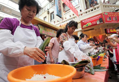 6月22日,市民在天津南市食品街舉行的“我們的節(jié)日·端午”系列活動(dòng)現(xiàn)場(chǎng)參加包粽子比賽。新華社發(fā)(劉東岳 攝)