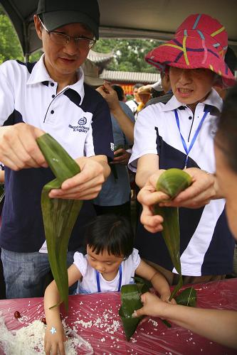 6月22日,市民在江蘇南京莫愁湖公園參加包粽子比賽。新華社發(fā)(王新 攝)