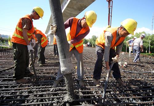 6月22日,建設(shè)者在新疆哈密貨車南環(huán)線迎賓路中橋澆筑現(xiàn)場(chǎng)施工。新華社發(fā)(蔡增樂 攝)