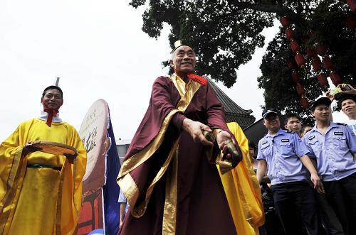 6月23日,在龍舟巡游開幕式上進行祭祀屈原表演的演員將粽子拋向龍舟隊員。新華社記者 陳曄華 攝