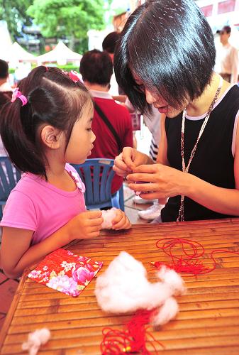 6月23日,在臺北市兒童育樂中心,小朋友在大人的協(xié)助下制作“香包”。新華社發(fā)(吳景騰 攝)