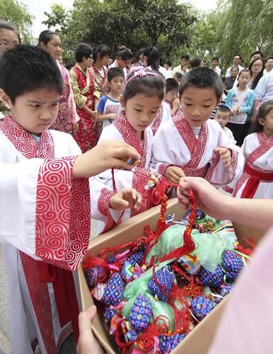 6月23日,南通知止堂國學班的小學員在“端午祭祀屈原儀式”結(jié)束后分取香囊,準備贈送給過往市民。當日是我國傳統(tǒng)節(jié)日端午節(jié),江蘇省南通市舉行“端午祭祀屈原儀式”,兩百余名來自該市知止堂國學班、實驗小學、南通中學西藏民族班的學生在家長及工作人員的陪同下齊聚濠河畔,觀摩、參與祭祀屈原儀式,感受端午節(jié)的文化內(nèi)涵。新華社發(fā)(黃哲 攝)
