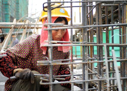 7月5日,一名女建筑工人在工地施工。 當(dāng)日,合肥市發(fā)布今年首個(gè)高溫橙色預(yù)警。在該市最大的保障性工程之一瑤海區(qū)雙窯洞棚戶區(qū)改造工程建筑工地,數(shù)百名建筑工人在暑熱下堅(jiān)持工作,確保保障房如期完工。 新華社記者 杜宇 攝