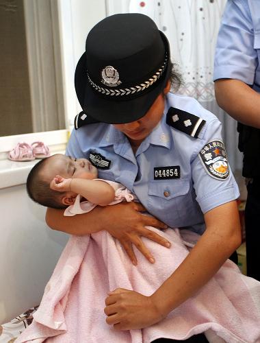 在河北唐縣,公安民警在解救7個(gè)月大的被拐女嬰(7月2日攝)。 7月2日,公安部統(tǒng)一指揮河北、山東、四川、福建、河南、云南等15省區(qū)市公安機(jī)關(guān)同步開展集中抓捕、解救行動(dòng),徹底摧毀了兩個(gè)危害極大的拐賣兒童犯罪團(tuán)伙,斬?cái)喙召u犯罪的鏈條,抓獲犯罪嫌疑人802名,解救被拐賣兒童181名。因販賣兒童一百余名被公安部發(fā)布A級(jí)通緝令通緝的主犯邵中元在集中抓捕行動(dòng)中落網(wǎng)。 新華社記者 王申 攝