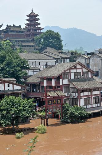 重慶嘉陵江洪峰過境 千年古鎮(zhèn)變水城 7月6日,磁器口古鎮(zhèn)的標志性建筑之一的磁器口大牌坊已經(jīng)被洪水淹沒過半。 當日,嘉陵江今年截至目前最大的洪峰通過重慶主城區(qū),在朝天門匯入長江。洪峰的抵達使流經(jīng)重慶主城區(qū)的嘉陵江水暴漲近3米,嘉陵江畔的千年古鎮(zhèn)磁器口變身“水城”。300余戶磁器口的商家在當?shù)卣M織下有序撤離,一排排明清建筑風格的商鋪浸泡在江水中,只露出青瓦頂,大量避險躉船只能將臨時人行通道直接搭在臨江商鋪的屋頂上。據(jù)設在磁器口的嘉陵江臨時水文監(jiān)測點監(jiān)測顯示,磁器口嘉陵江水位在當日上午11時達到了183.85米,至下午14時開始逐步減退,預計嘉陵江今天至后天水位將可能陡退12.58米。 新華社記者 劉潺 攝