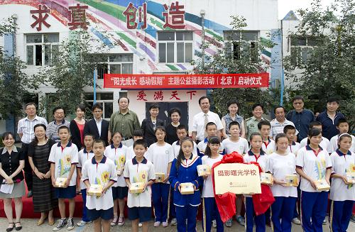 7月13日,獲贈(zèng)相機(jī)的孩子們與出席活動(dòng)的嘉賓合影。當(dāng)日,“陽(yáng)光成長(zhǎng) 感動(dòng)假期”主題公益攝影活動(dòng)在北京市第一所專(zhuān)門(mén)為進(jìn)城務(wù)工人員子女創(chuàng)辦的中學(xué)——蒲公英中學(xué)啟動(dòng),由中國(guó)攝影家協(xié)會(huì)與蒲公英中學(xué)共建的“攝影曙光學(xué)校”也正式掛牌。據(jù)悉,這一活動(dòng)旨在培養(yǎng)進(jìn)城務(wù)工人員子女、孤殘兒童等特殊群體的攝影興趣,發(fā)掘和支持其攝影天賦與興趣發(fā)展。目前,由中國(guó)攝協(xié)與全國(guó)10所中小學(xué)校共建的第一批“攝影曙光學(xué)校”已全部掛牌。新華社記者 王曄 攝