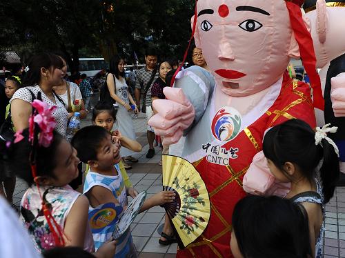 7月13日,孩子們與扮成唐僧的工作人員互動(dòng)。新華社記者 金良快 攝